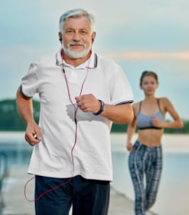 Senior Man Listening Music Running Near Lake Evening